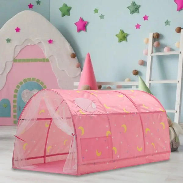 Une tente de lit rose avec motif lunes pour enfant est installée par terre dans une chambre rose et verte. 