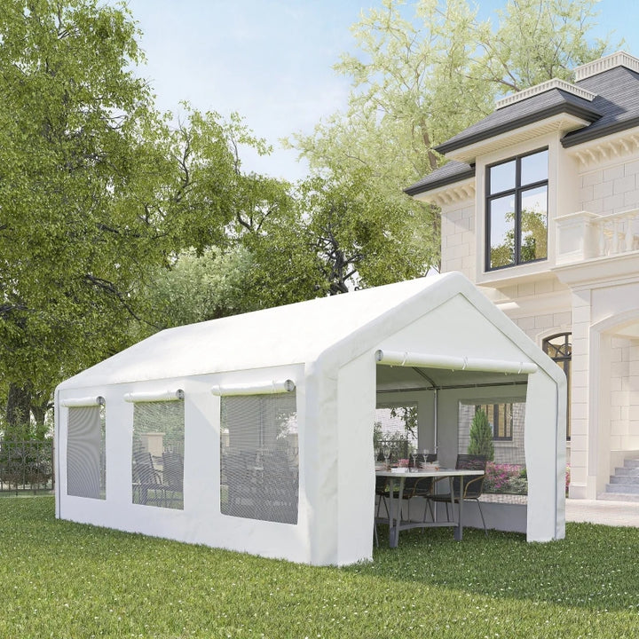 Une tente de réception blanche est installée dans un jardin devant une maison. La tente a deux portes et six fenêtres. Elle peut accueillir 8 personnes 