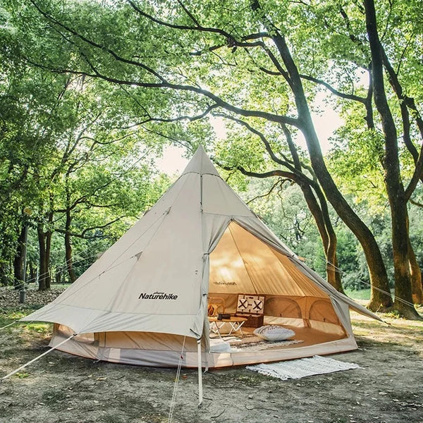 Un tipi beige est installé dans la nature. C'est une tente beige pour 4 personnes. 