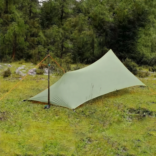 C'est une toile de tente verte de camping ultra légère. Elle est dans la nature, en lisière de forêt. 