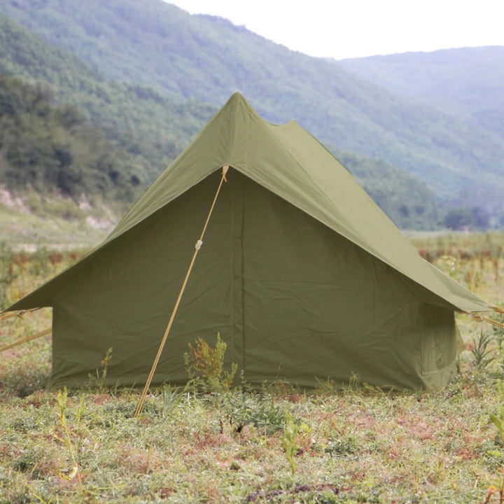 Une tente canadienne kaki militaire est installée dans la nature. Elle est faite pour 1-2 personnes. 