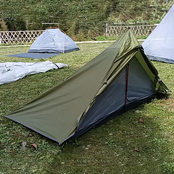 Une tente de trekking tipi militaire avec une chambre  est installée dans la nature. 
