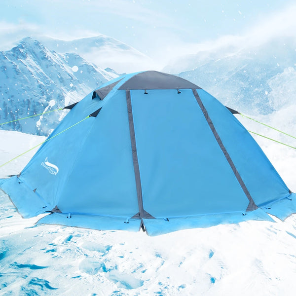 Une tente bleue est installée sur une montagne enneigée. Elle est fermée.