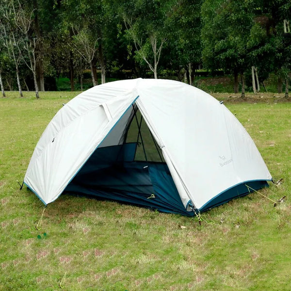 Une tente ronde blanche est installée dans un parc. La tente est ultra légère.